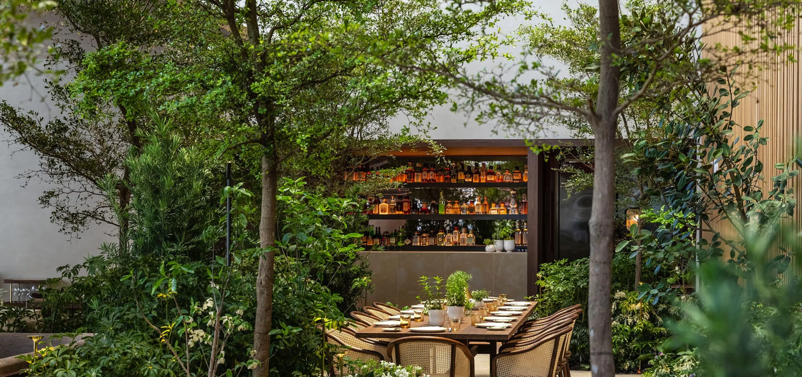 View of exterior dining table in the garden at Le Pavillon