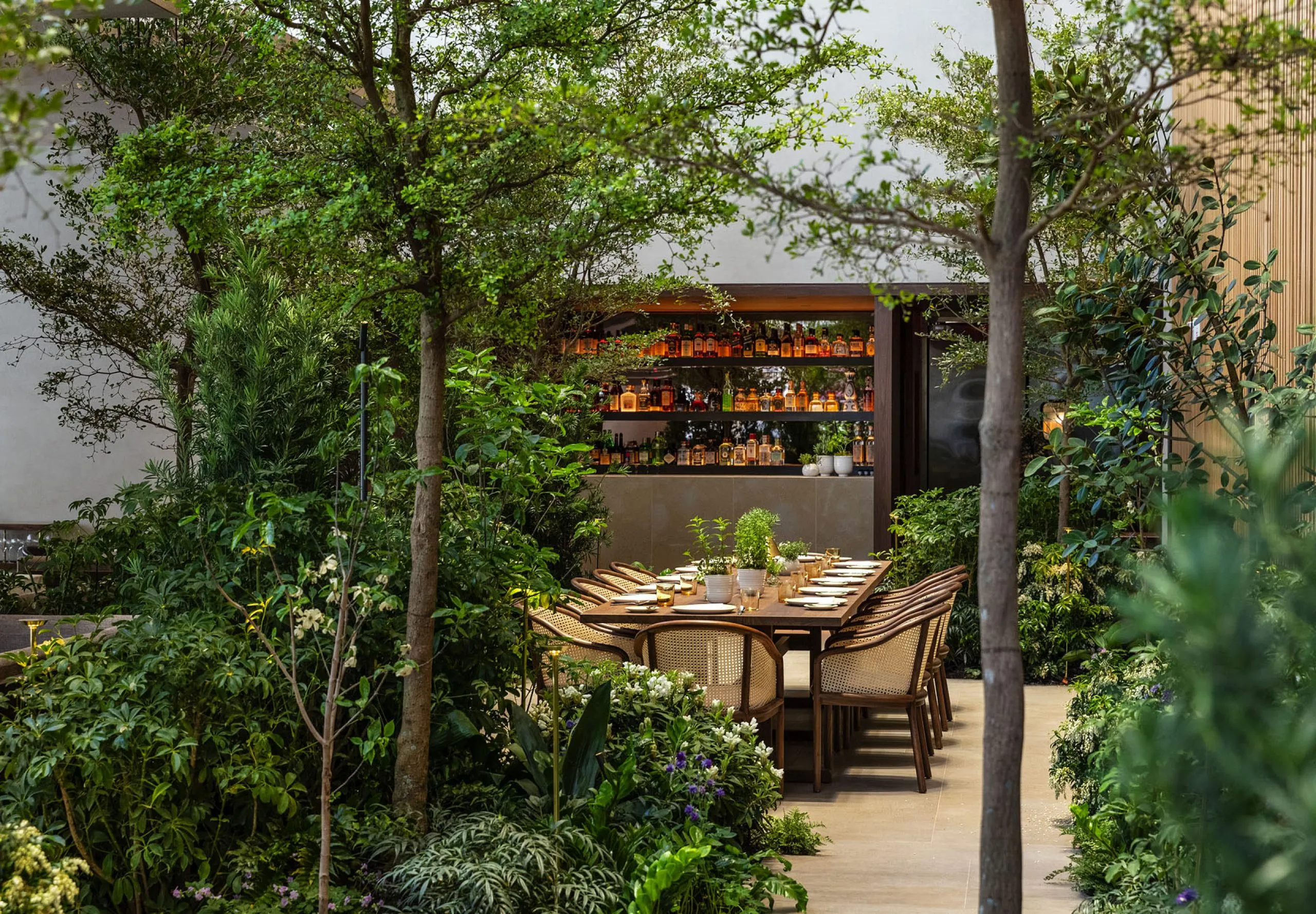 View of exterior dining table in the garden at Le Pavillon