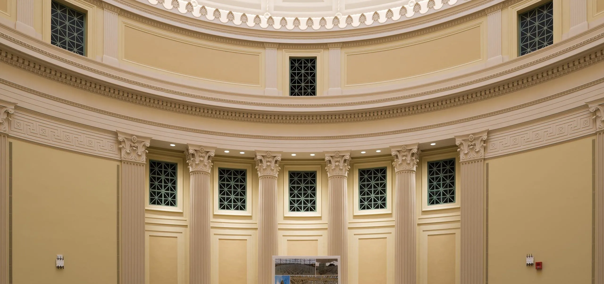 a large room with columns and a large picture frame