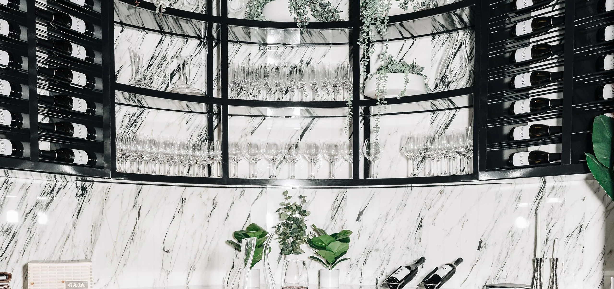 Interior view of a white marble bar and wine rack at RPM Italian