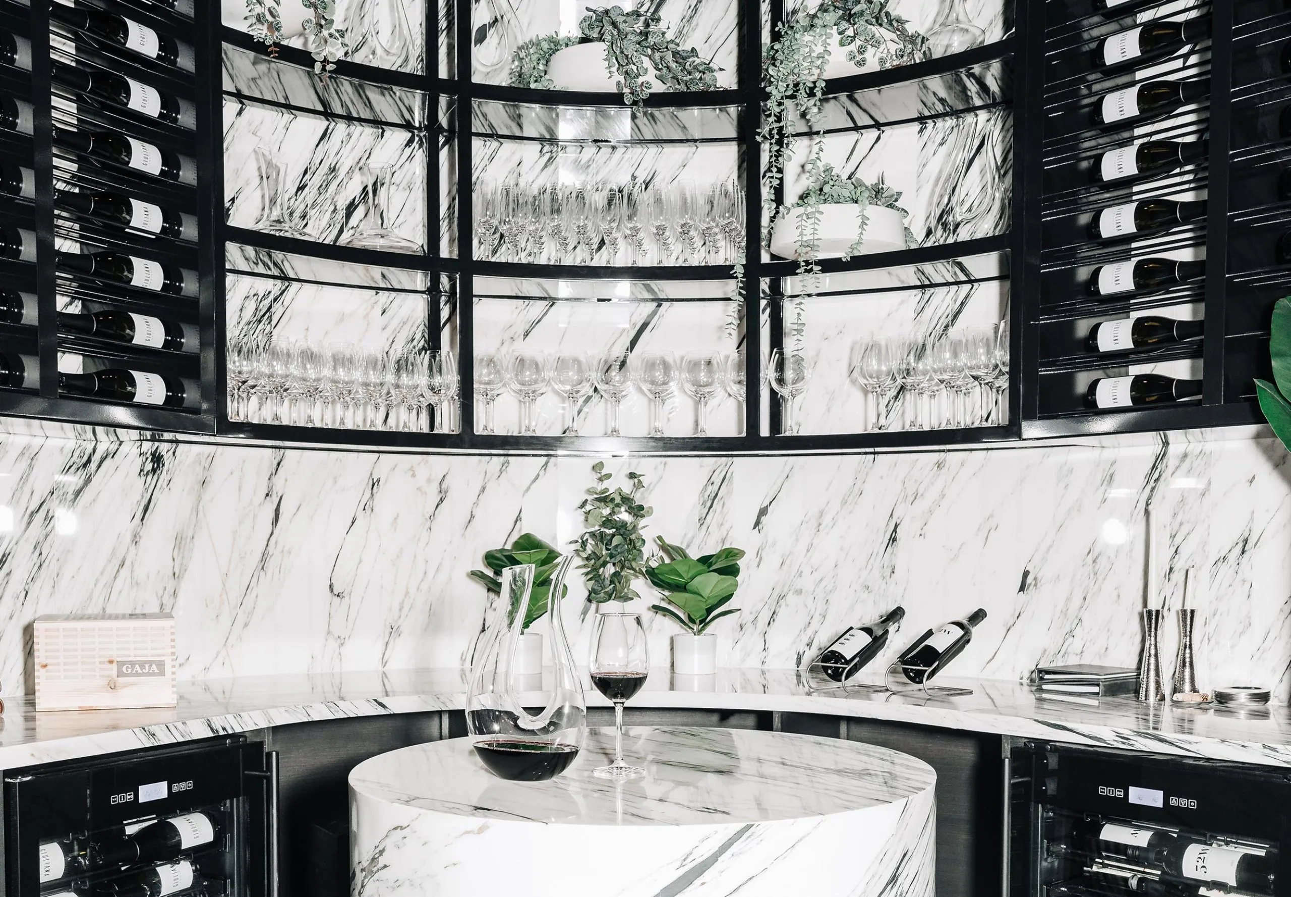 Interior view of a white marble bar and wine rack at RPM Italian