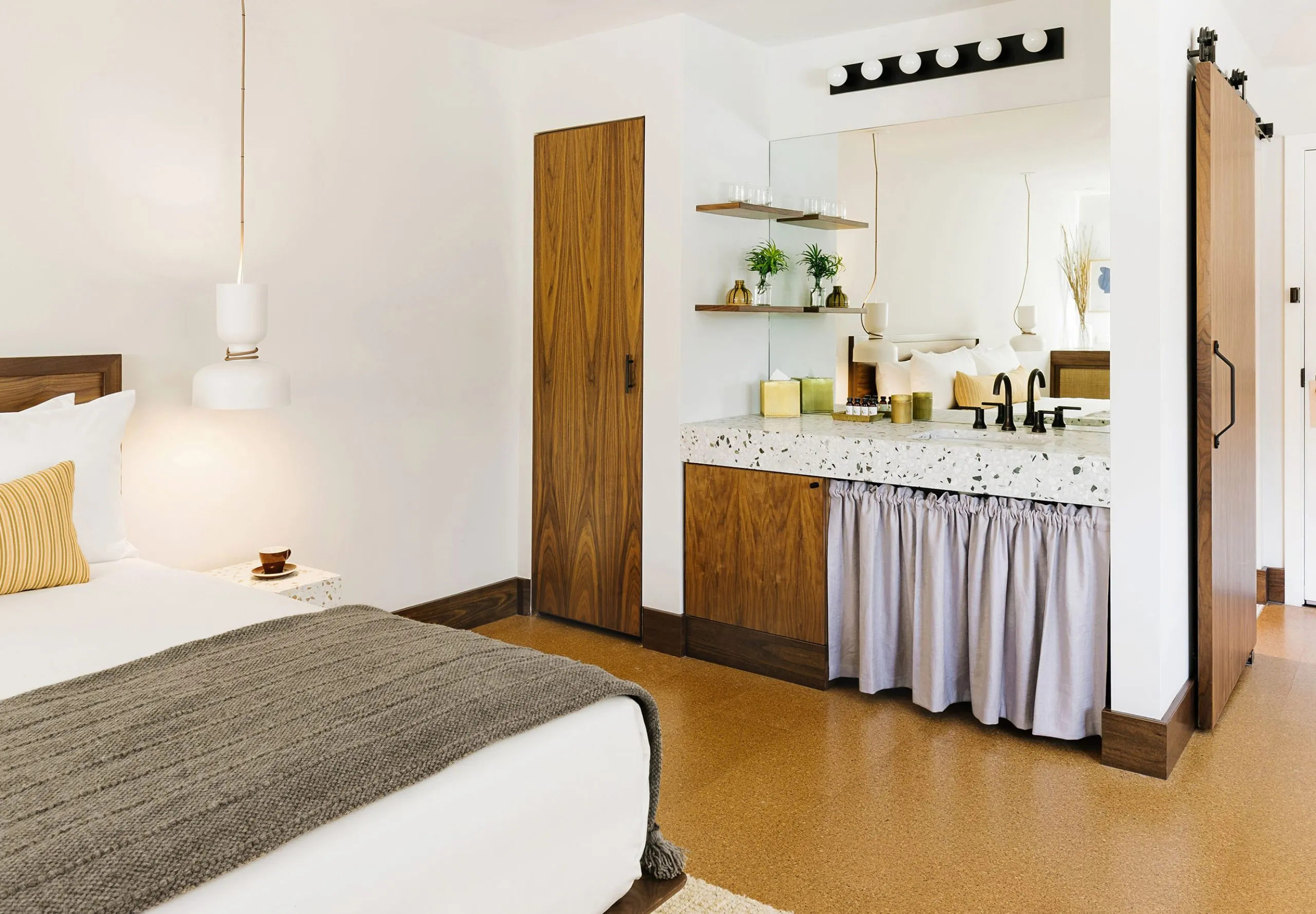 Interior view of a hotel room sink and bed at the Silver Lake Pool Inn