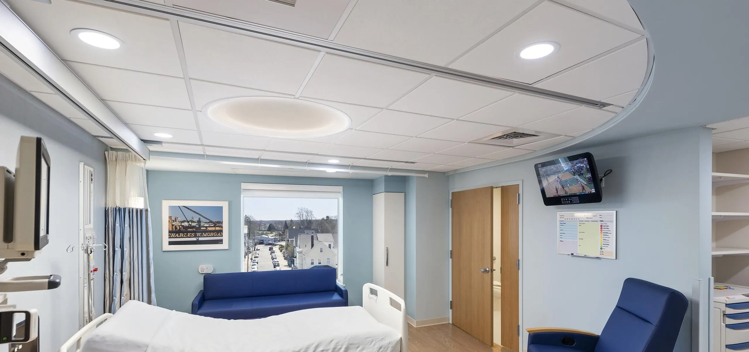 Interior view of a hospital room with a bed, blue couch and chair at St. Luke's Hospital