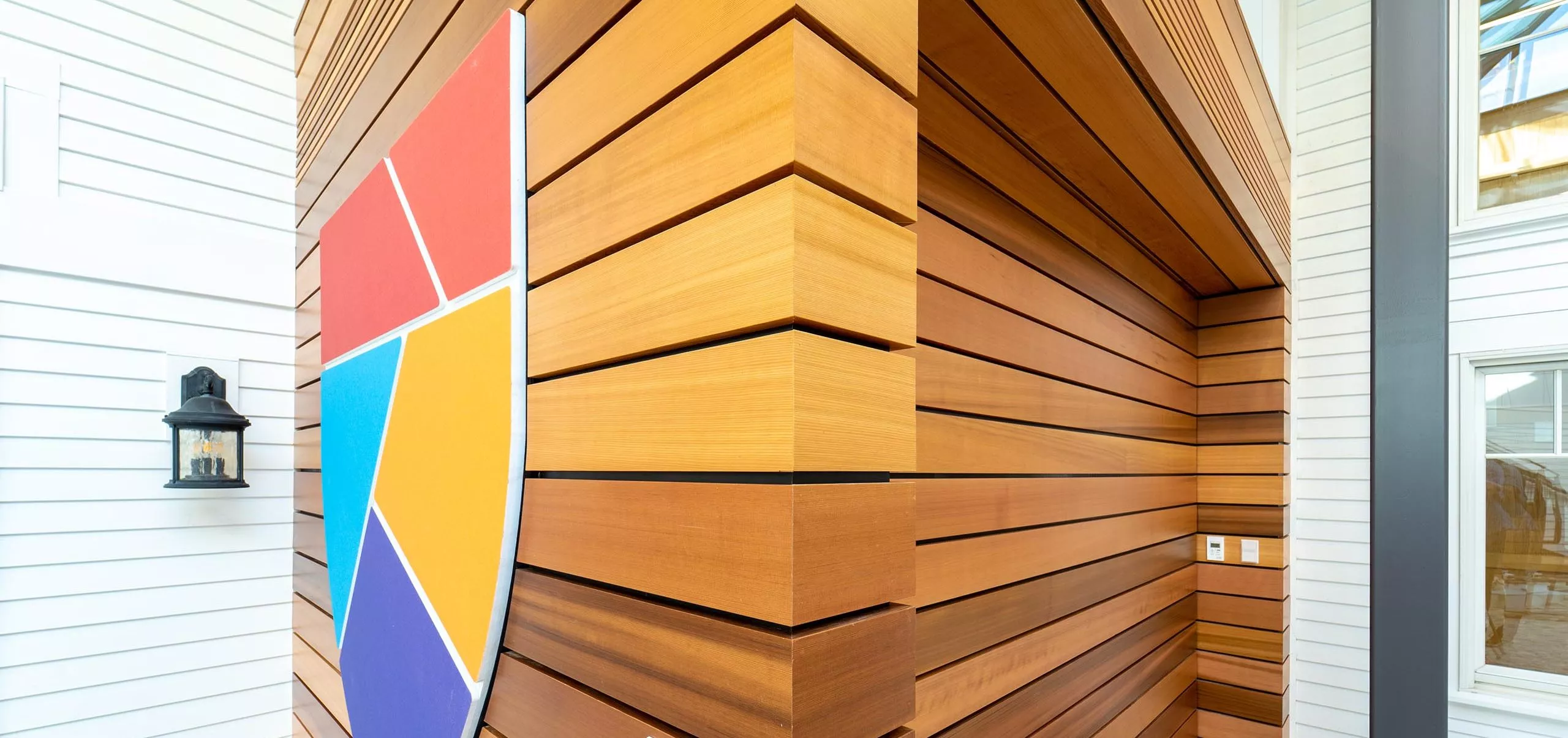 Wood veneer wall and shield logo on the wall of Governor's Academy French Student Center