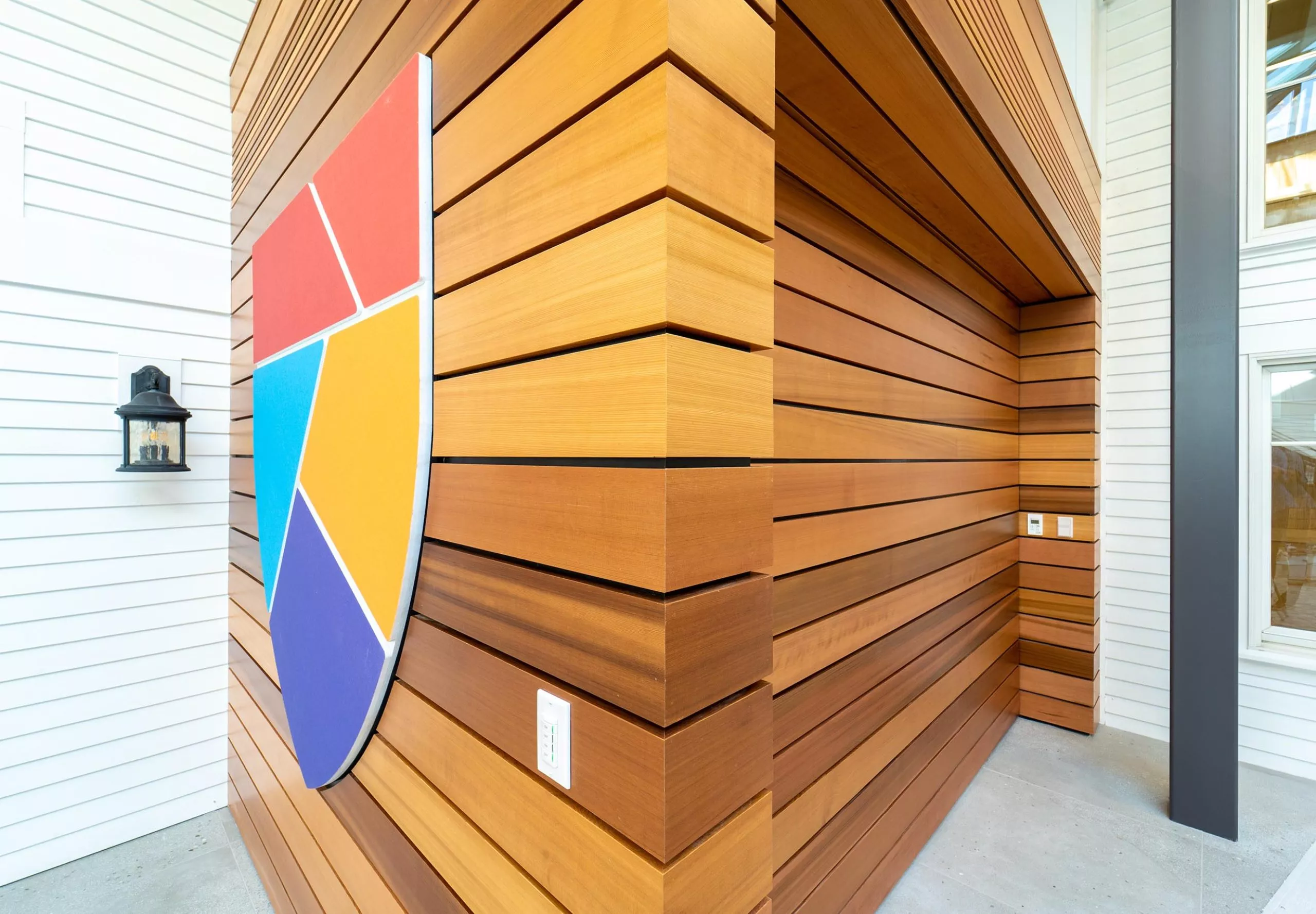 Wood veneer wall and shield logo on the wall of Governor's Academy French Student Center