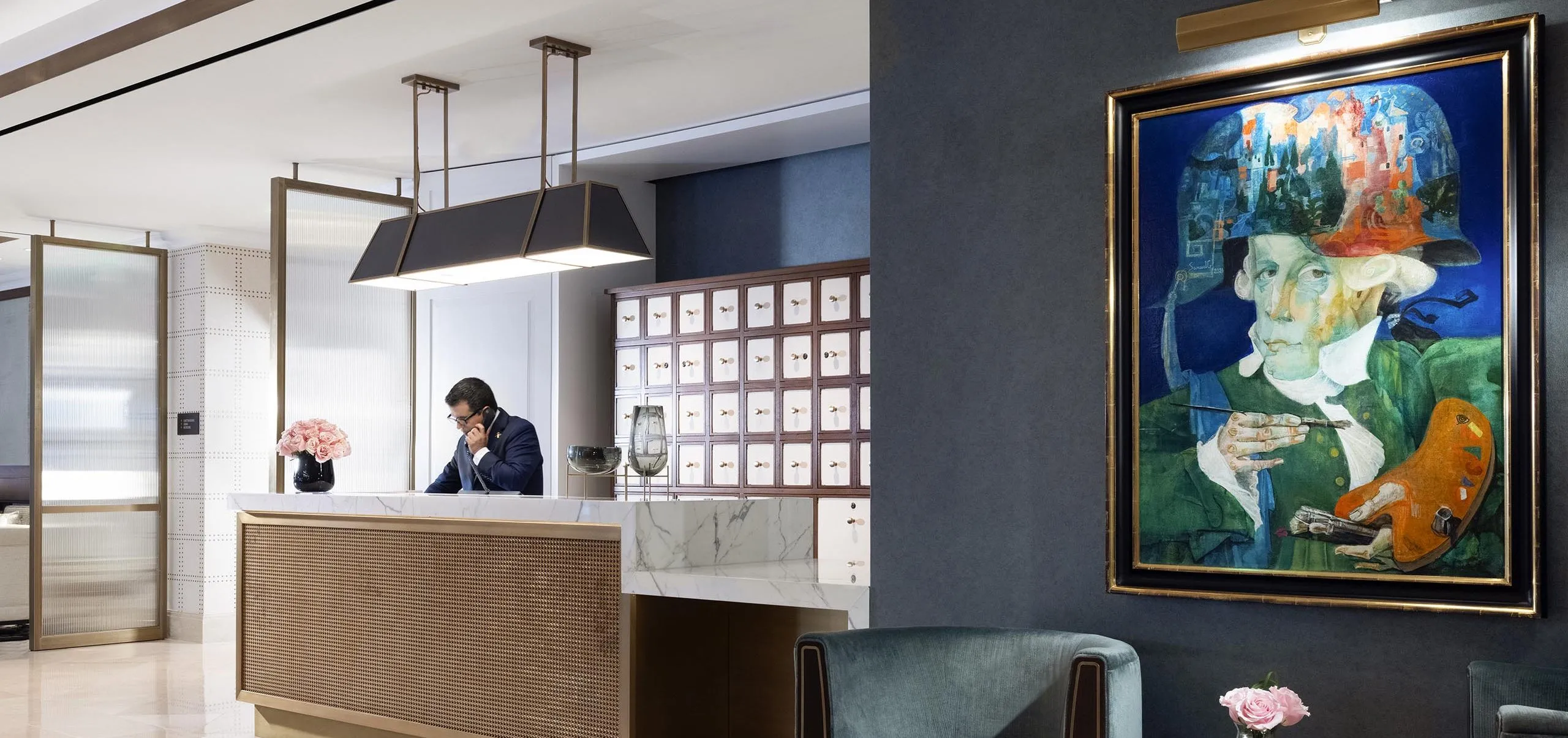 Interior view of the lobby with a man at the front desk on the phone at The Langham Boston