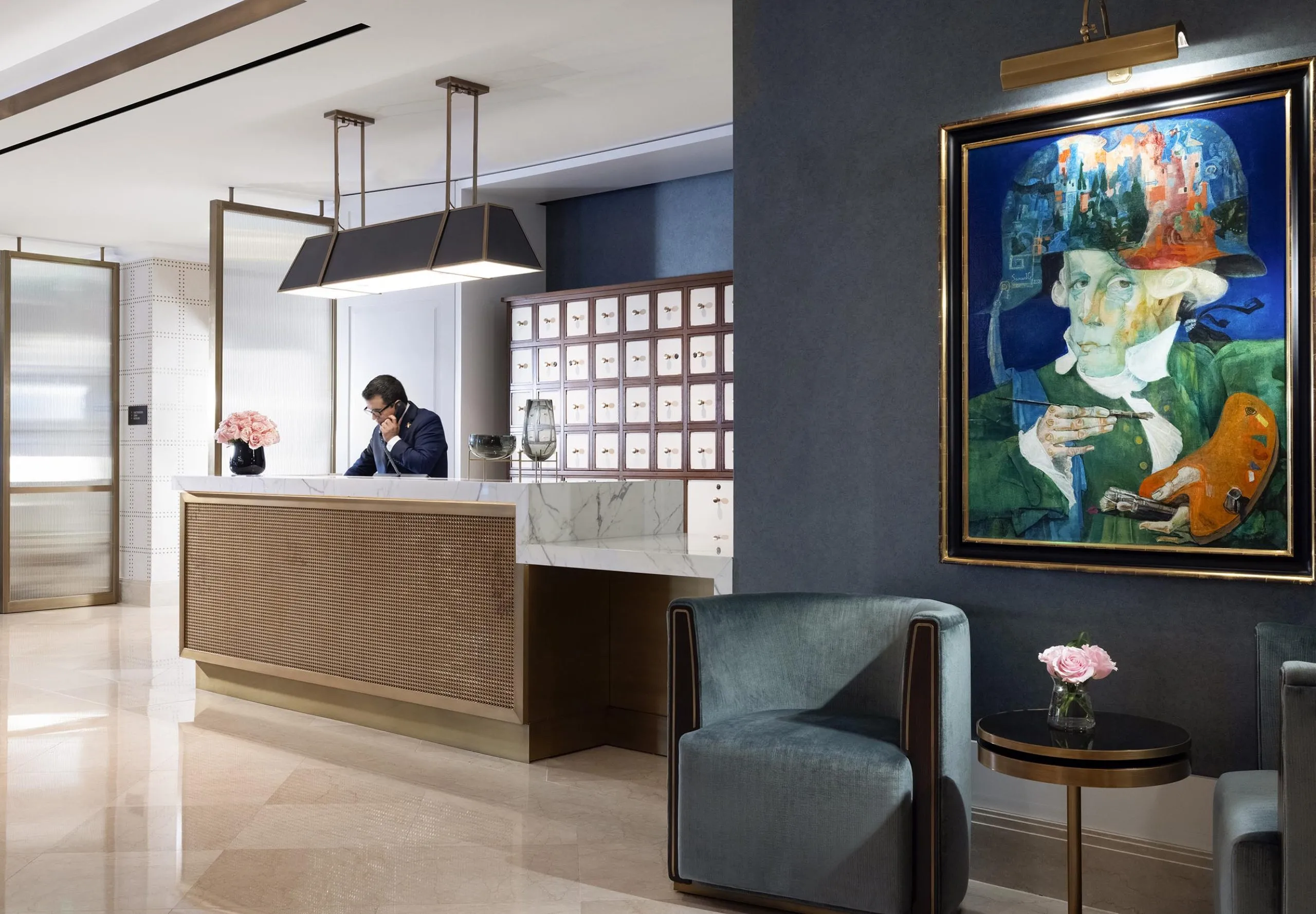 Interior view of the lobby with a man at the front desk on the phone at The Langham Boston