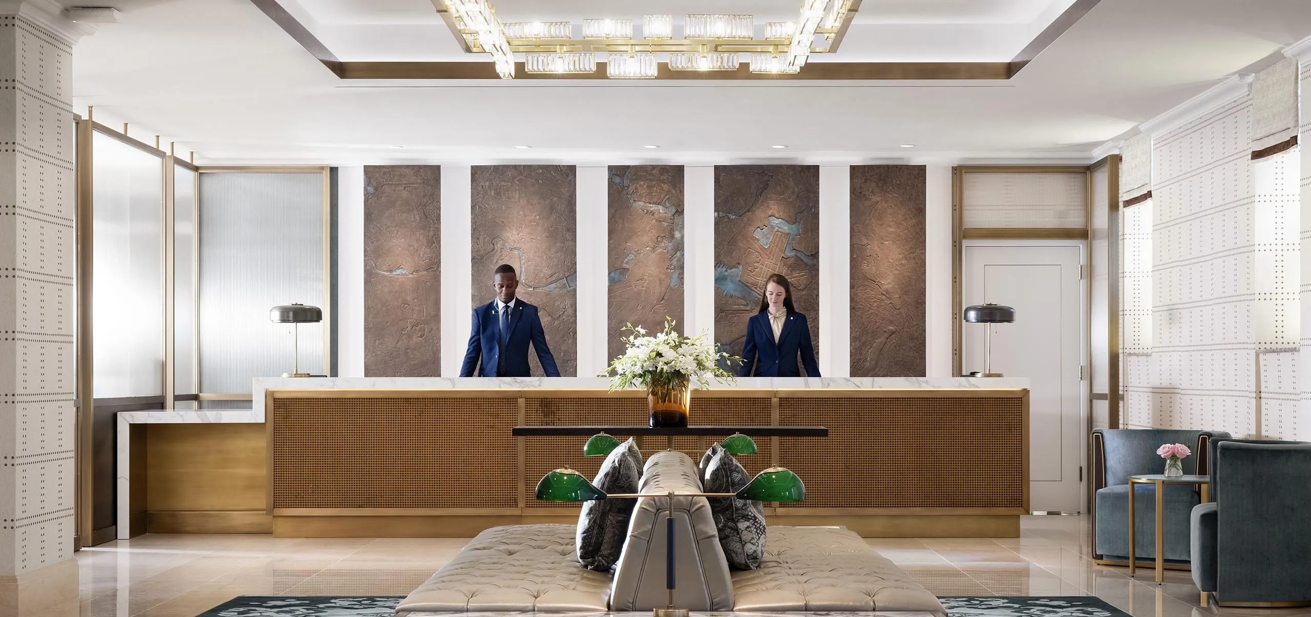 Interior view of the lobby with two employees at The Langham Boston