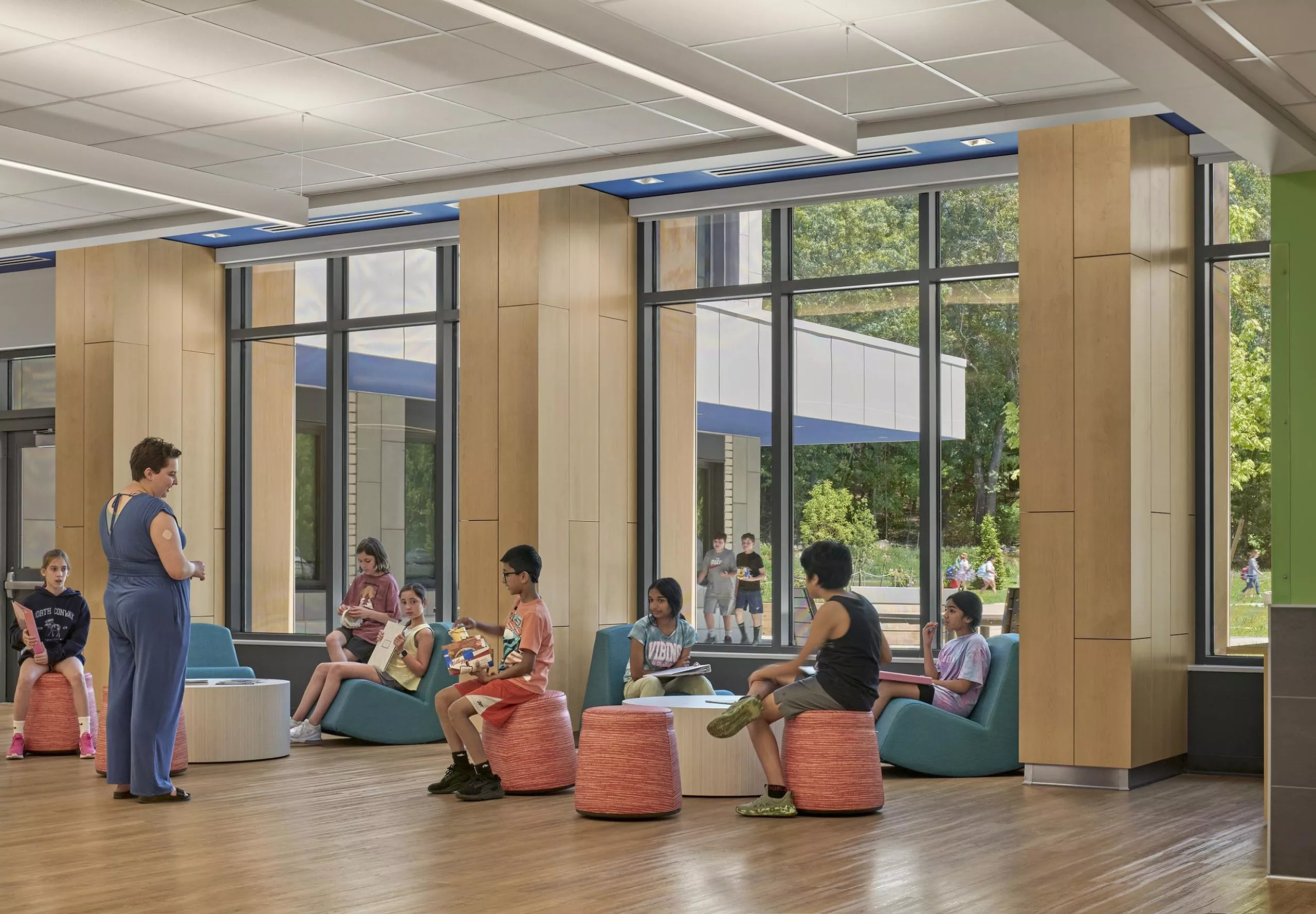 Children sitting in communal space at David Mindess Elementarry School