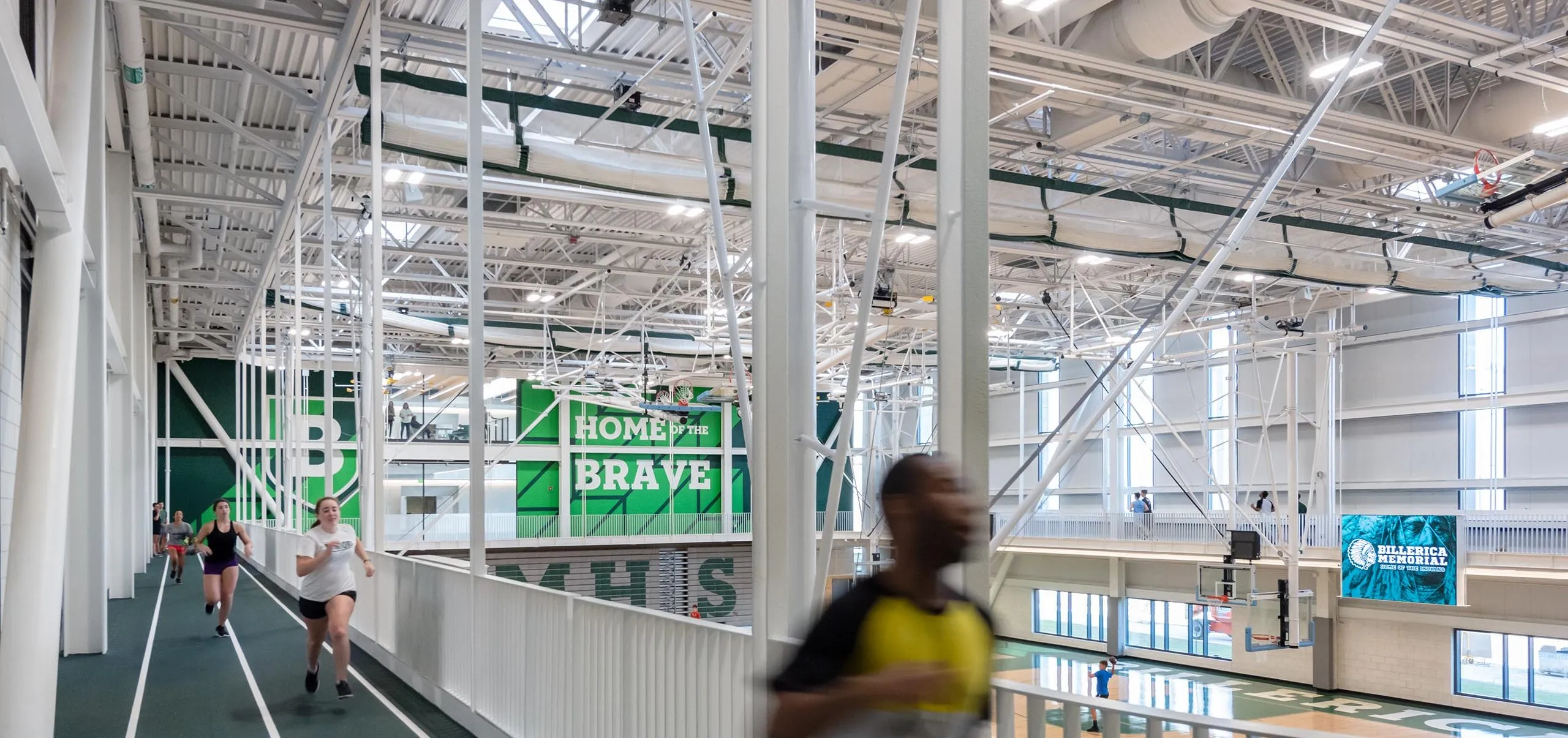 Students running around elevated track in gym Billerica Memorial High School