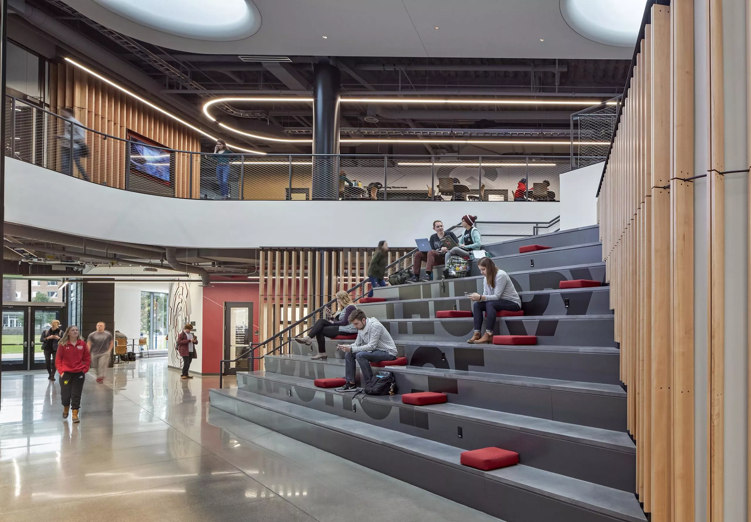 People sitting on the large stairs in Innovation Studio & Messenger Residence Hall