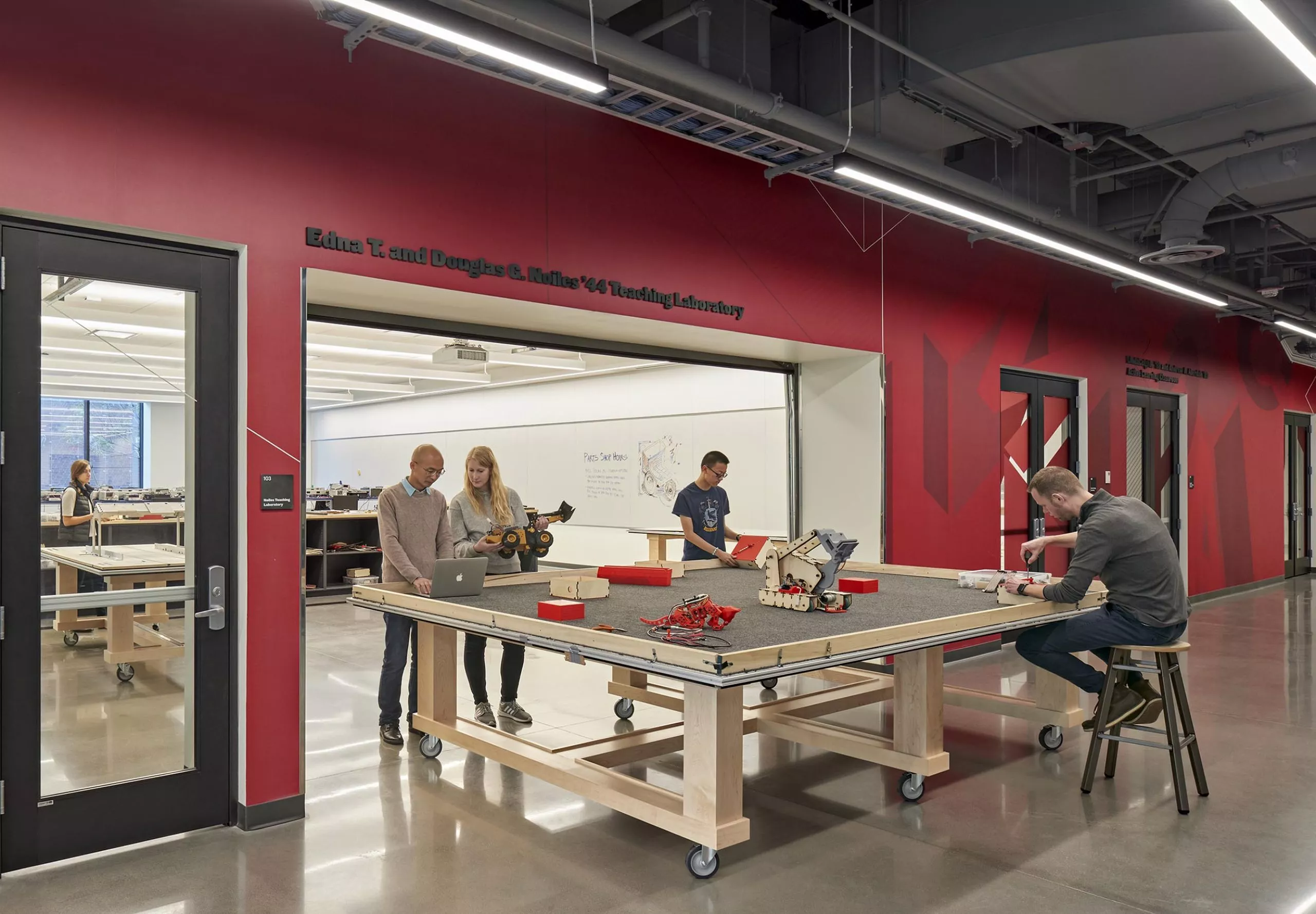 A group of people in a room working on robotics in Innovation Studio & Messenger Residence Hall