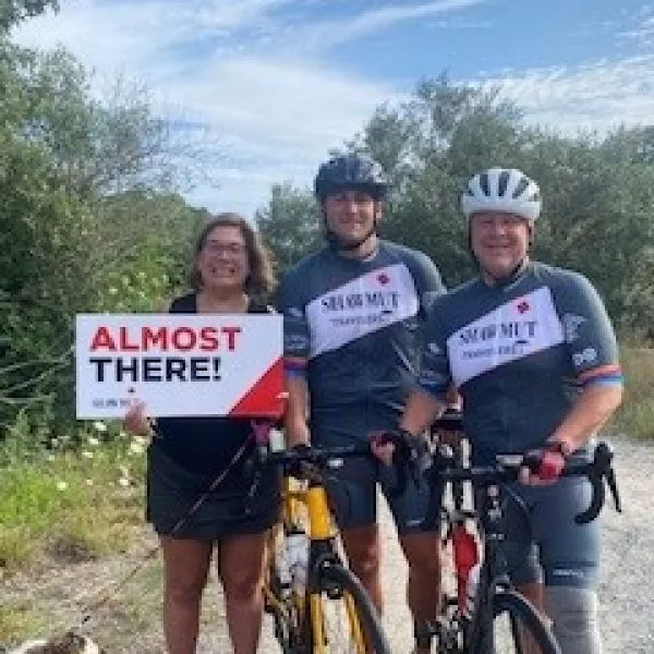 Craig Stevens in Shawmut biking gear with mountain bike and two other people