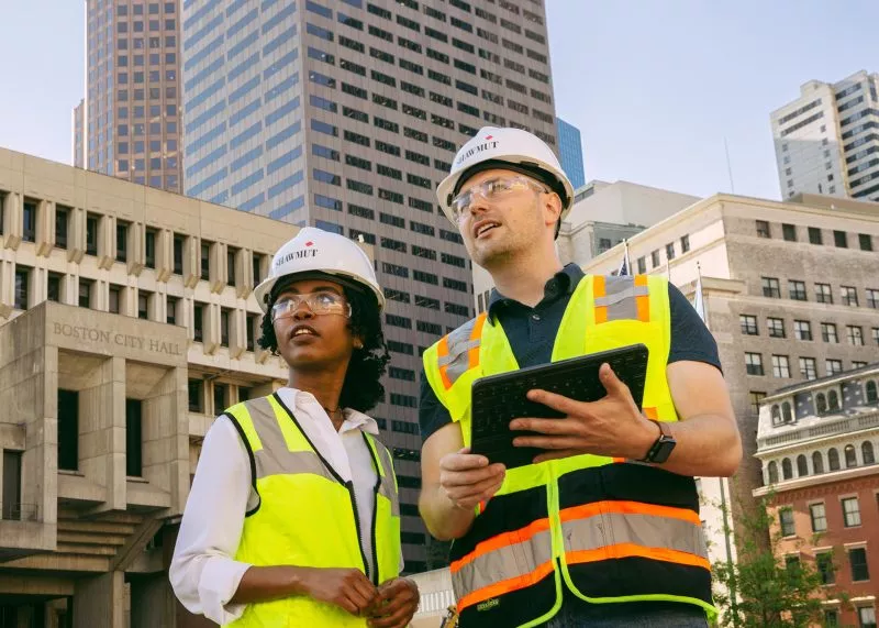 Two employees in construction gear looking up