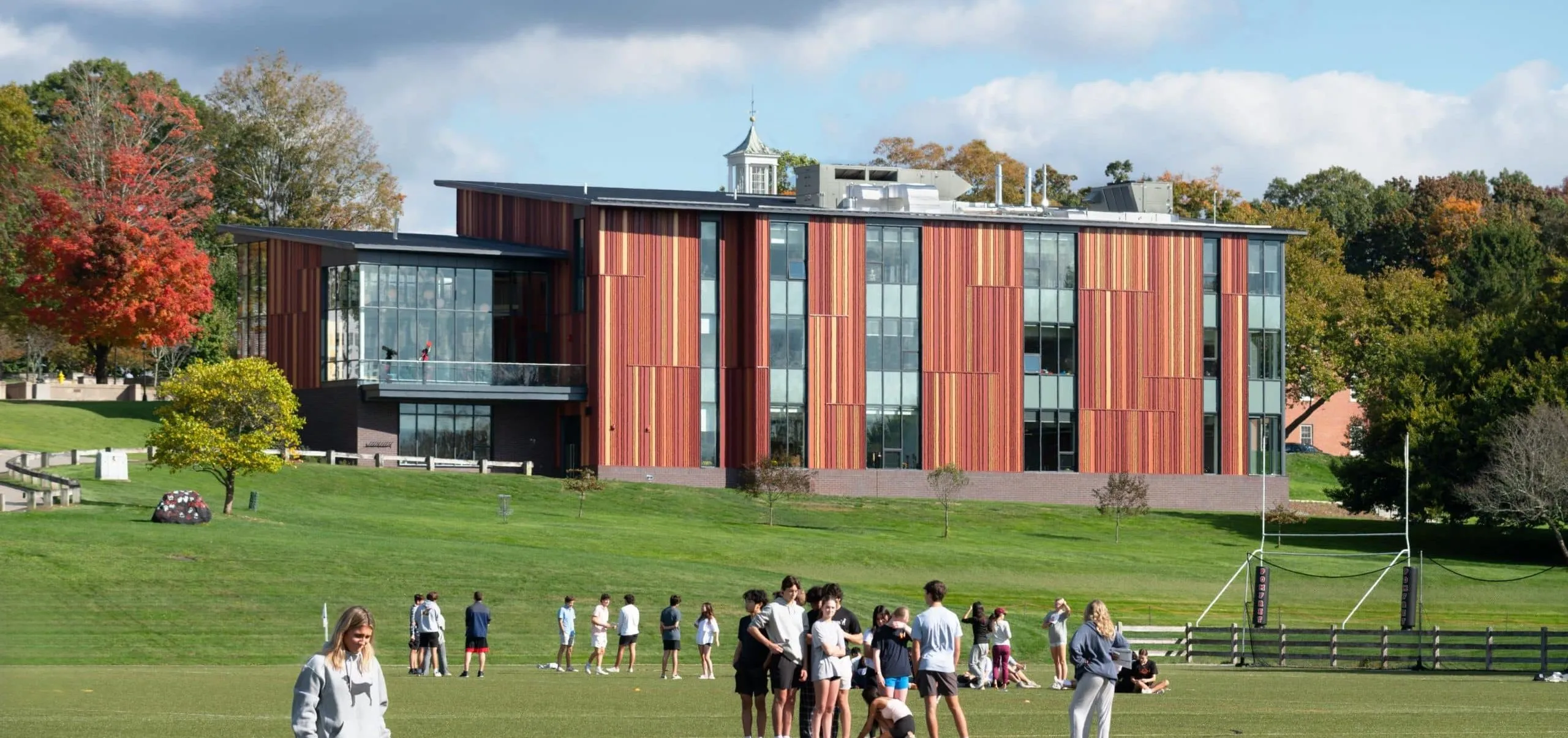 People standing in field with modern VISTA building in distance