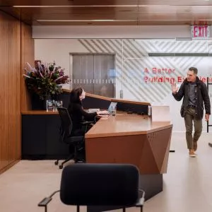 Person waving at receptionist as they enter Shawmut office